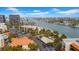 Aerial view showing condo building, waterfront, and nearby amenities at 7537 Bayshore Dr # 406, Treasure Island, FL 33706