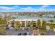 Aerial view of waterfront condo building with parking and recreational areas at 7537 Bayshore Dr # 406, Treasure Island, FL 33706