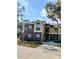 Brick condo building with stairs leading to entrance and surrounding trees at 8702 Mallard Reserve Dr # 104, Tampa, FL 33614