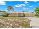 Tan single-story house with a two-car garage and mature landscaping at 1085 Indian Rocks S Rd, Largo, FL 33770