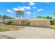 Tan single-story house with a two-car garage and mature landscaping at 1085 Indian Rocks S Rd, Largo, FL 33770