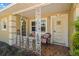 Front porch with ornate railings, two chairs, and terracotta tile flooring at 1085 Indian Rocks S Rd, Largo, FL 33770