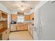Galley kitchen featuring wood cabinets and white appliances at 1085 Indian Rocks S Rd, Largo, FL 33770