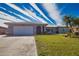 Single story home with a two-car garage and lush lawn at 1290 Cambridge Dr, Venice, FL 34293