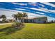 Single story home with a large grassy yard and palm trees at 1290 Cambridge Dr, Venice, FL 34293