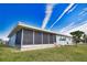 House exterior showcasing screened lanai and landscaping at 1290 Cambridge Dr, Venice, FL 34293