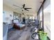 Bright sunroom features wicker furniture, tile flooring, and a ceiling fan at 1290 Cambridge Dr, Venice, FL 34293