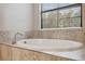 Oval freestanding bathtub with tile surround in a bright bathroom at 14786 Horse Trot Rd, Lithia, FL 33547