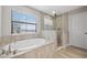 Elegant bathroom with soaking tub, shower, and tile flooring at 14786 Horse Trot Rd, Lithia, FL 33547