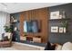 Living room features a stylish media wall with floating shelves and a large TV at 14786 Horse Trot Rd, Lithia, FL 33547