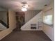 Living room with staircase, stone wall, and mirrored wall at 1820 Bough Ave # 3, Clearwater, FL 33760
