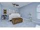 Bedroom with white wooden bed frame and striped ottoman at 19304 Garden Quilt Cir, Lutz, FL 33558