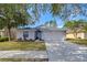 Gray house with a two-car garage and landscaped lawn at 19304 Garden Quilt Cir, Lutz, FL 33558