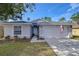 Gray house with American flag, two-car garage, and landscaped lawn at 19304 Garden Quilt Cir, Lutz, FL 33558
