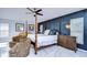 Main bedroom with king-size bed, ceiling fan, and dark blue accent wall at 19304 Garden Quilt Cir, Lutz, FL 33558