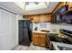 Bright kitchen, featuring black refrigerator and wood cabinets at 204 Lennox W Rd, Palm Harbor, FL 34683