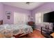 Bright bedroom with double doors, hardwood floors, and a large TV at 3457 Foxhall Dr, Holiday, FL 34691