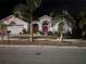 Night view of a single-Gathering home with palm trees and landscaping at 3457 Foxhall Dr, Holiday, FL 34691