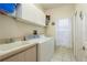 Laundry room with washer, dryer, cabinets, and utility sink at 3457 Foxhall Dr, Holiday, FL 34691