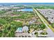 Aerial view of community, featuring a pool, lush landscaping, and serene lake at 5230 Admiral Pointe Dr, Apollo Beach, FL 33572