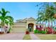 Tan two-story house with a three-car garage and lush landscaping at 5230 Admiral Pointe Dr, Apollo Beach, FL 33572