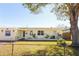 House exterior showcasing a light yellow painted home with a large tree in the front yard at 6554 34Th N Ave, St Petersburg, FL 33710