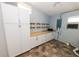 Bright laundry room with white cabinets, shelving, and hexagon tile floor at 6554 34Th N Ave, St Petersburg, FL 33710