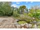 Landscaped backyard with a pond and brick path at 6774 Treehaven Dr, Spring Hill, FL 34606