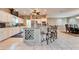 Island kitchen with white cabinets, granite counters and tile flooring at 861 Symphony Isles Blvd, Apollo Beach, FL 33572
