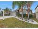 Two-story house with a landscaped yard, paver driveway and palm trees at 10405 White Peacock Pl, Riverview, FL 33578