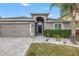 Curb appeal abounds with this charming home featuring a well-manicured lawn and paver driveway at 10405 White Peacock Pl, Riverview, FL 33578