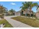 House exterior view showcasing landscaping, driveway, and palm trees at 10405 White Peacock Pl, Riverview, FL 33578