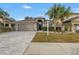 Two-story house with a gray garage door and paver driveway at 10405 White Peacock Pl, Riverview, FL 33578