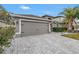 Two-story house with a gray garage door and paver driveway at 10405 White Peacock Pl, Riverview, FL 33578