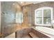 Luxurious bathroom with soaking tub, walk-in shower, and marble tile at 105 Wimbledon Ct, Redington Shores, FL 33708