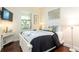 Bright bedroom with a queen-size bed and hardwood floors at 105 Wimbledon Ct, Redington Shores, FL 33708