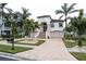 Two-story house with a red door, palm trees, and a brick driveway at 105 Wimbledon Ct, Redington Shores, FL 33708