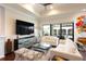 Bright living room with comfy seating, large TV, and sliding glass doors leading to a balcony at 105 Wimbledon Ct, Redington Shores, FL 33708