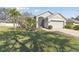 House with a two-car garage, palm trees, and a well-kept lawn at 11140 Irish Moss Ave, Riverview, FL 33569