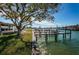 Waterfront backyard with dock and mature tree at 11650 4Th E St, Treasure Island, FL 33706