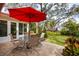 Relaxing patio with seating area and red umbrella at 1320 Fairway Dr, Dunedin, FL 34698