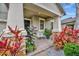 Covered front porch with seating area and tropical landscaping at 13355 Orca Sound Dr, Riverview, FL 33579