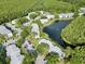 Aerial view of community with lake and lush landscaping at 1344 Pine Ridge E Cir # D2, Tarpon Springs, FL 34688