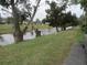 Waterfront view of canal, lush vegetation, and part of neighboring building at 1515 Forrest Nelson Blvd # E108, Port Charlotte, FL 33952