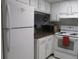 White kitchen with appliances and dark countertops at 1515 Forrest Nelson Blvd # E108, Port Charlotte, FL 33952