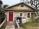 Tan single story house with red door, small deck, and landscaping at 1602 Saffold Park Dr, Ruskin, FL 33570