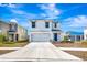 Two-story house with white exterior, two-car garage, and landscaped lawn at 17033 Oval Rum Dr, Wimauma, FL 33598