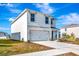 Two-story home with white exterior and attached garage at 17033 Oval Rum Dr, Wimauma, FL 33598