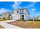 Two-story house with white exterior, two-car garage, and landscaping at 17033 Oval Rum Dr, Wimauma, FL 33598