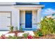 Blue front door entry with nicely landscaped walkway at 17033 Oval Rum Dr, Wimauma, FL 33598